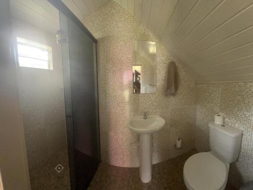 ein Badezimmer mit einem weißen WC und einem Waschbecken in der Unterkunft Pousada Voo Livre - Ilha do Mel in Ilha do Mel