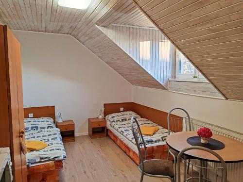a room with two beds and a table and a window at Ubytovanie LISKA in Radava