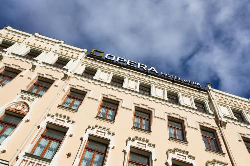 a building with a sign on the top of it at Opera Hotel in Rīga