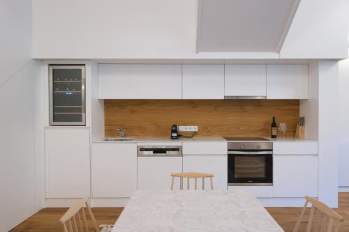 a kitchen with white cabinets and a table and chairs at Stampferei in Sichauf