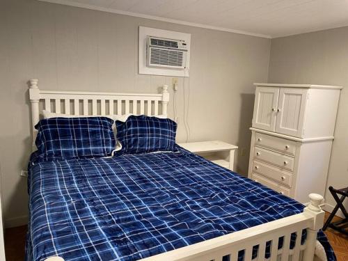 1 dormitorio con 1 cama con edredón de cuadros azul en Modern Woodland Cabin With Pool View, en Salisbury