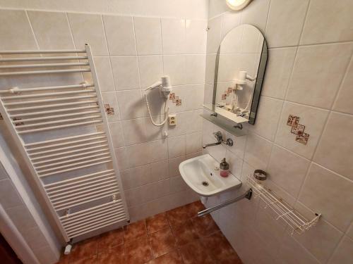 a white bathroom with a sink and a mirror at Ubytovanie LISKA in Radava
