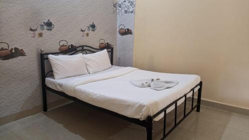 - un lit avec des draps blancs et une serviette dans l'établissement HOTEL VITU SIA CALANGUTE BEACH, à Calangute