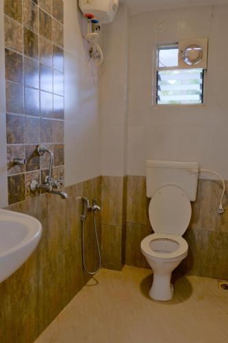 La salle de bains est pourvue de toilettes et d'un lavabo. dans l'établissement HOTEL VITU SIA CALANGUTE BEACH, à Calangute