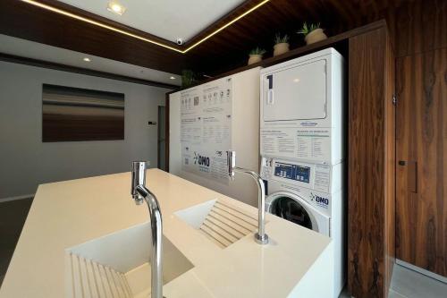 uma cozinha com uma máquina de lavar roupa e uma máquina de lavar roupa em Zainalofts7 Moema - 1km Ibira e 200m metrô 213 ID em São Paulo