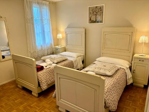 a bedroom with two beds and a mirror at La Fabbrica Delle Idee in Fonte