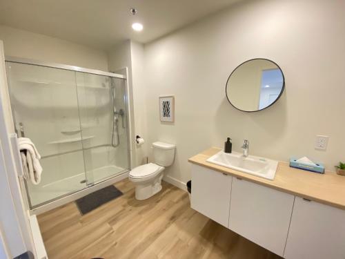 a bathroom with a shower and a toilet and a sink at APPART-HOTEL L'UNI in Quebec City