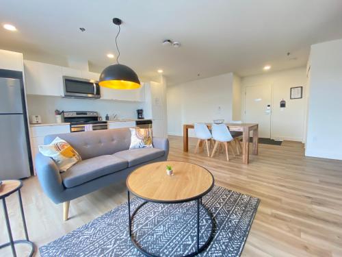 a living room with a couch and a table at APPART-HOTEL L'UNI in Quebec City