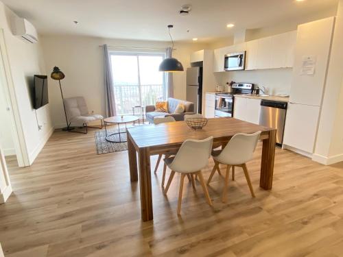 a kitchen and dining room with a table and chairs at APPART-HOTEL L'UNI in Quebec City