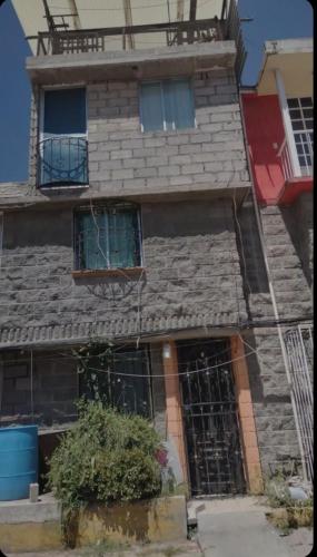 Cette maison en pierre dispose de deux fenêtres et d'un balcon. dans l'établissement Lucia, à Mexico