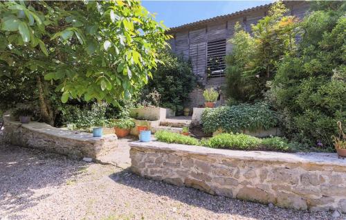 un jardin avec un mur en pierre et quelques plantes dans l'établissement Cottage l'Atelier, piscine, terrain de loisirs, à Marigny