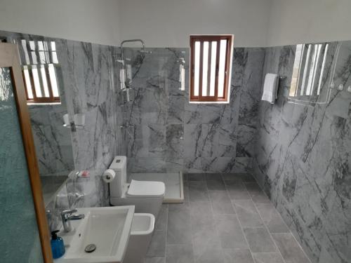 y baño con aseo y lavamanos. en Villa Besart en Berat