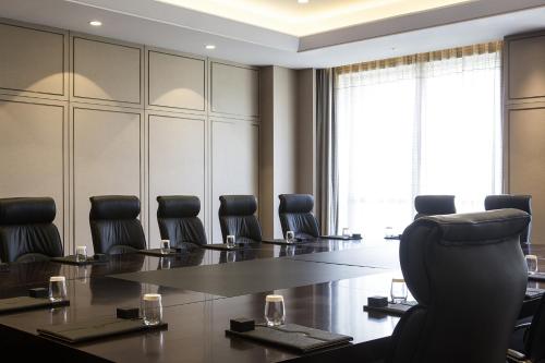 a conference room with a large table and chairs at Pullman Taiyuan in Taiyuan