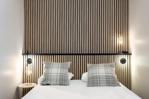 une chambre avec un lit avec deux oreillers dans l'établissement L37 F1 Central 2 min de la mer Balcon & CLIM, à Nice