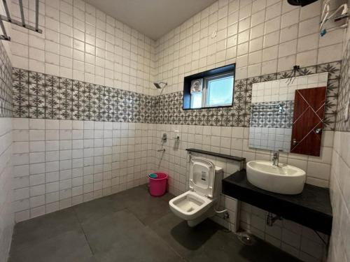 een badkamer met een toilet en een wastafel bij Sanjay Home Stay in Kodaikānāl