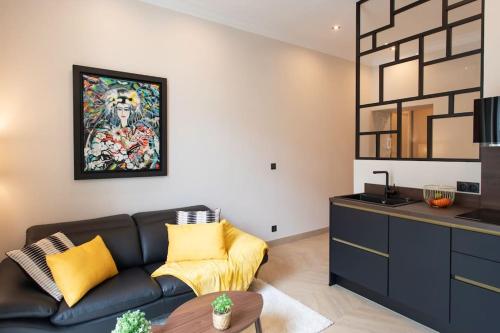 un salon avec un canapé et un tableau au mur dans l'établissement L37 F1 Central 2 min de la mer Balcon & CLIM, à Nice
