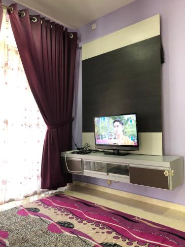 een woonkamer met een flatscreen-tv aan de muur bij Homestay Kuala Terengganu Gong Badak in Kuala Terengganu