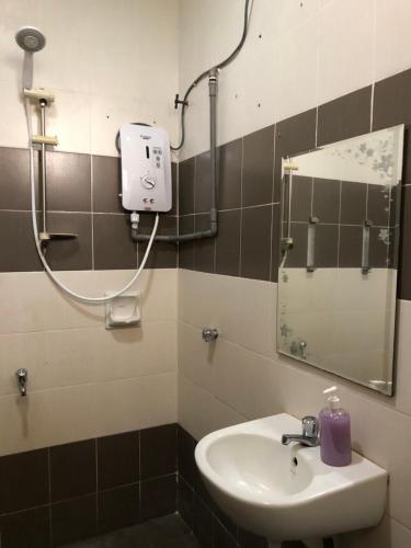 een badkamer met een wastafel en een spiegel bij Homestay Kuala Terengganu Gong Badak in Kuala Terengganu
