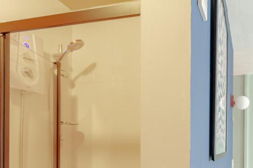 La salle de bains est pourvue d'une douche et d'une porte en verre. dans l'établissement Trendy Studio near Notting Hill, à Londres