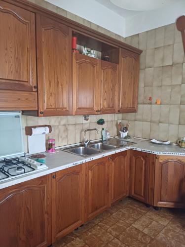 a kitchen with wooden cabinets and a sink at La casa di Lili in Lugnano in Teverina