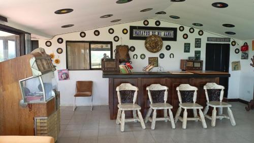 a room with a bar with four stools at Finca Maratón Alto in Calarcá