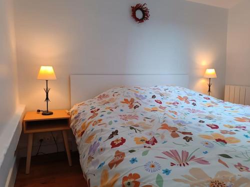 - un lit avec une couette colorée et une table avec des lampes dans l'établissement Appartement proche centre historique, à Rouen