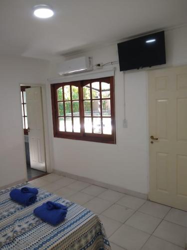 a bedroom with a bed with two blue pillows on it at Casa Amplia 5 personas con Jardin y Parrilla in Tigre