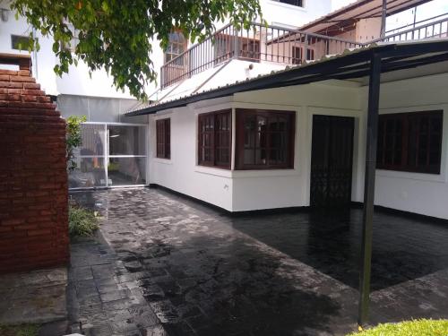an empty courtyard of a white building with a balcony at Casa Amplia 5 personas con Jardin y Parrilla in Tigre
