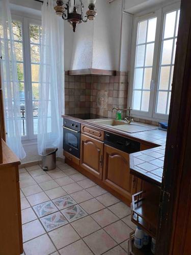 Maison chaleureuse en face de la forêt - proche INSEAD في فونتينبلو: مطبخ مع مغسلة وموقد