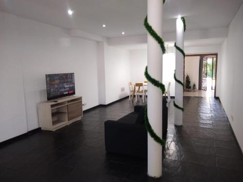 a living room with a tv and a couch and a table at Casa Amplia 5 personas con Jardin y Parrilla in Tigre