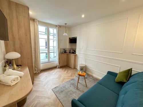 un salon avec un canapé bleu et une table dans l'établissement Appartement élégant au cœur de Saint-Germain-des-Prés, à Paris