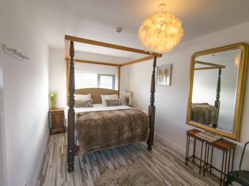 een slaapkamer met een hemelbed en een spiegel bij Mocha Newcastle in Galway