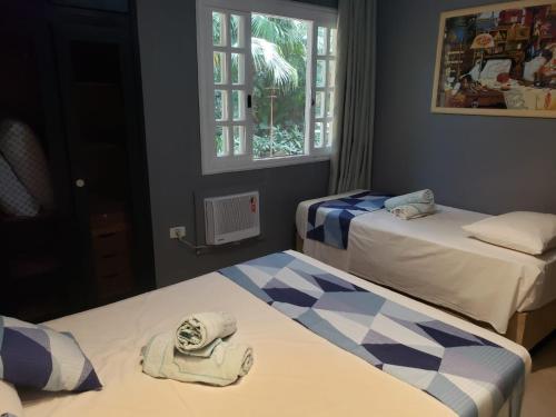 um quarto com duas camas com toalhas em Amarilis Flat Maravilhoso - com serviço de hotelaria, sauna e piscinas climatizadas em Rivera de São Lourenço