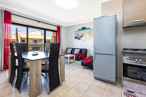 a kitchen and dining room with a table and a refrigerator at Mar & Serra in Armação de Pêra