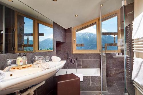 a bathroom with a sink and a shower at Hotel Tirol Fiss 4Sterne Superior in Fiss