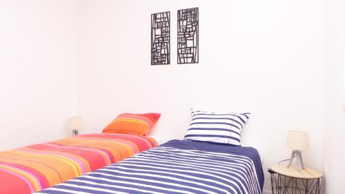 twee bedden in een kamer met kleurrijke strepen bij Ti An Alré, appartement 4 p en centre ville in Auray