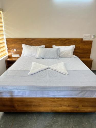 BAVA AC Rooms at Casa de Aadi في فاركَالا: غرفة نوم مع سرير مع قوس عليه