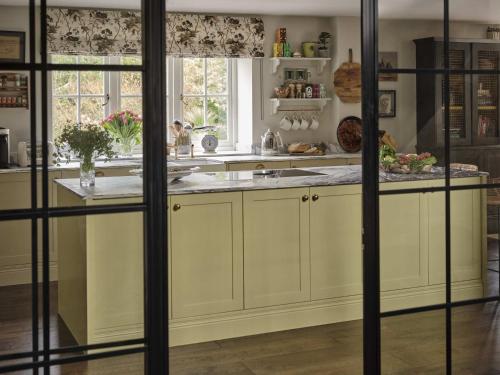 a kitchen with white cabinets and a counter at Plum House in Haslemere