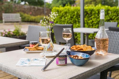 普雷讷夫昂德雷Studio proche de la mer à Pléneuf-Val-André的一张桌子,上面放着两杯葡萄酒和一碗食物