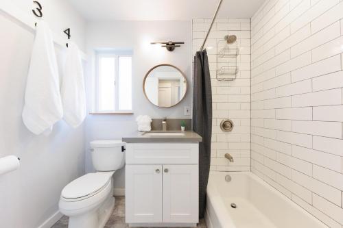 e bagno bianco con servizi igienici, lavandino e vasca. di Walk to Beach, Outdoor Living, Pet-Friendly! a Carlsbad