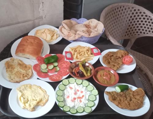 a table with plates of different types of food at pyramids old stone view in Cairo