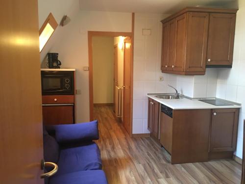 a small kitchen with wooden cabinets and a sink at Apartamento CENTRO FORMIGAL in Formigal