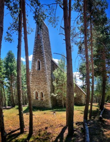 an old stone church in the middle of trees at Casa rural de lujo en Alt Urgell, Pirineos. in Aravell