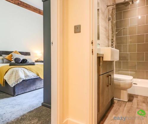 a bedroom with a bed and a bathroom with a toilet at Cambridge Mews in Cleethorpes