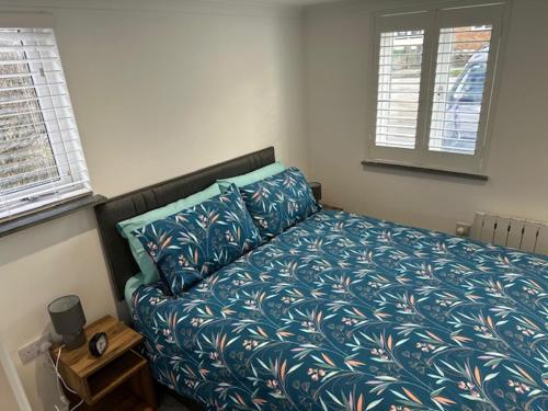 1 dormitorio con 1 cama con edredón azul en HeyRic, en Padstow