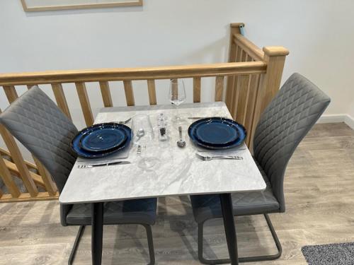 a white table with two chairs and a blue plate at HeyRic in Padstow
