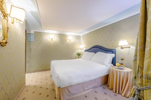 a hotel room with a bed and a shower at Hotel Colombina in Venice