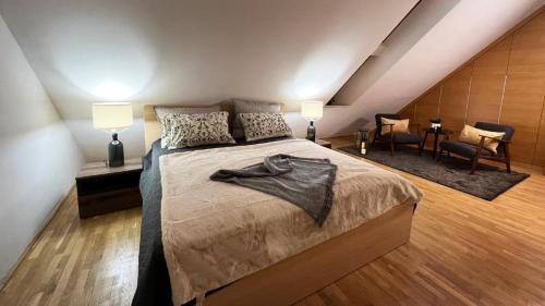 a bedroom with a bed and two lamps and chairs at PENTHOUSE Synagogue - by Artemisia Luxury Apartments in Budapest