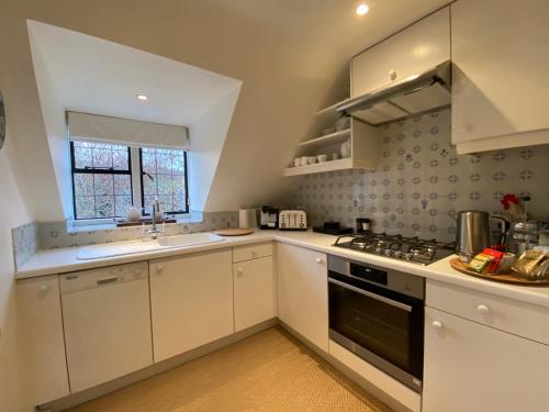 a kitchen with white cabinets and a stove top oven at Mill Hay Country House in Broadway