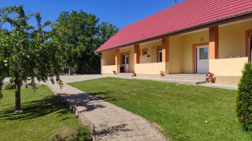 a building with a red roof and a grass yard at Ubytovanie LISKA in Radava